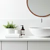 A clean and minimalist bathroom countertop with a sink, mirror, and various toiletries. Anteprima dell’immagine prodotto