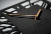 A close-up shot of a modern black wall clock with gold hands. Anteprima dell’immagine prodotto