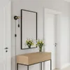 A hallway with a console table, mirror, and wall lamp. Produktbild-Vorschau
