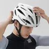 A man is putting on a white bicycle helmet. Produktbild-Vorschau