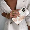 A woman's hand wearing rings and a bracelet holds a phone case. Náhled obrázku produktu