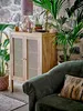 A living room scene with a wooden cabinet, plants, and a sofa. Produktbild-Vorschau