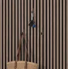 Hooks mounted on a slatted wooden wall, holding a bag and keys. Voir les images du produit