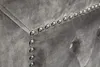Close-up view of a gray tufted upholstered furniture corner with decorative nailhead trim. Náhled obrázku produktu