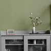 A digital weather station with a wooden frame sits on top of a gray cabinet, next to a vase with dried flowers. Podgląd zdjęcia produktu