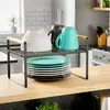 A kitchen shelf organizer holding plates, bowls, and mugs on a countertop. Anteprima dell’immagine prodotto