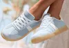 Close-up of a person's feet wearing light blue and white sneakers. Produktbild-Vorschau