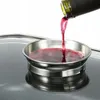 Red wine is being poured from a bottle into a stainless steel coaster. Produktbild-Vorschau