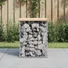 A gabion garden bench with a wooden top sits on a paved patio in front of a wooden fence and greenery. Produktbild-Vorschau