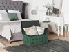 A bedroom scene with a bed, a storage ottoman, and a console table. Produktbild-Vorschau