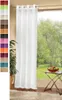 A white sheer curtain hangs in front of a window with a view of greenery. A small table with a bowl of fruit is to the right. Produktbild-Vorschau