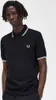 A man wearing a black Fred Perry polo shirt. Produktbild-Vorschau