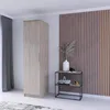 A tall wooden wardrobe stands next to a small shelf with decor against a slatted wall. Voir les images du produit
