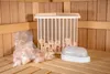 A close-up view of a sauna interior, showing a bag of pink salt crystals, a wooden basket filled with salt crystals, and a white light fixture on a wooden bench. Produktbild-Vorschau