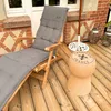A lounge chair and a cork-shaped stool on a wooden deck next to a brick wall. Produktbild-Vorschau