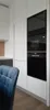 A modern kitchen with built-in appliances and a chair in the foreground. Produktbild-Vorschau