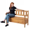 A woman sits on a wooden storage bench against a white background. Náhled obrázku produktu