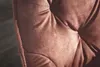 Close-up of a tufted velvet chair or sofa cushion in a reddish-brown color. The background is a dark, out-of-focus floor. Produktbild-Vorschau