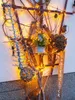 A decorative garden trellis adorned with fairy lights, ornaments, and a small potted plant. Produktbild-Vorschau