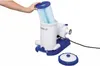 A hand is inserting a filter cartridge into a pool pump. A separate lid is on the surface below. Voir les images du produit