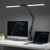A black adjustable LED desk lamp is positioned above a desk with a computer monitor and a laptop. Náhľad obrázku produktu