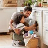 A father and child are doing laundry together, putting dryer balls into a washing machine. Produktbild-Vorschau