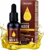 A bottle of Skoczylas ADEK vitamins in drops, with its packaging, surrounded by splashing oil. Voir les images du produit