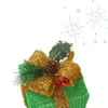 A decorated green gift box with a gold bow, pine sprigs, a pinecone, and red berries, set against a white background with decorative elements. Podgląd zdjęcia produktu