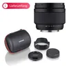 A product shot of a camera lens and its accessories, including a carrying case, lens hood, and lens caps. Voir les images du produit