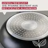 The underside of a black frying pan with a silver, dimpled surface is shown. Text overlays are present in the top left corner, and a leaf illustration is in the bottom right. Produktbild-Vorschau