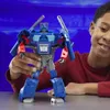 A young boy is holding a blue and red robot toy. Anteprima dell’immagine prodotto