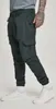 A person wearing black cargo jogging pants and white sneakers. Anteprima dell’immagine prodotto