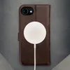 A dark brown leather iPhone case with a white wireless charger attached to it. Produktbild-Vorschau