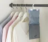 A dehumidifier hanging in a closet with clothes. Náhled obrázku produktu