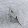 A roll of grey textured wallpaper is shown in a close-up shot, with the roll partially unfurled. Produktbild-Vorschau