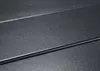 A close-up, angled view of a textured, dark gray surface with two parallel raised lines running horizontally across the frame. Podgląd zdjęcia produktu
