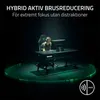 A person wearing headphones sits at a desk with a computer, illuminated by a green glow. Náhľad obrázku produktu
