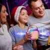 A family is gathered around a pink portable Bluetooth speaker with colorful RGB lights, suggesting a festive or celebratory occasion. Náhľad obrázku produktu