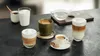 A collection of coffee and tea drinks arranged on a dark countertop. Náhled obrázku produktu