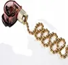 A close-up of a gold beaded pull chain attached to a transparent and gold switch. Podgląd zdjęcia produktu
