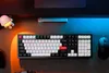 A top-down view of a mechanical keyboard and mouse on a desk, illuminated by colorful LED lights. Produktbild-Vorschau