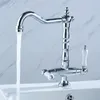 A chrome kitchen faucet with white ceramic handles is shown with water running from the spout. Náhled obrázku produktu