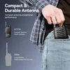 A person is putting a compact walkie-talkie into their jeans pocket, with a comparison to a larger walkie-talkie shown on the left. Voir les images du produit