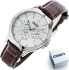 A close-up, slightly angled shot of a Casio watch with a white face and a brown leather strap, placed on a white background. A small Casio branded box is visible in the lower right corner. Produktbild-Vorschau