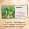 An open booklet with an illustration on the left and text on the right, placed on a wooden surface. Produktbild-Vorschau