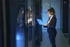 A woman in a server room using a laptop. Anteprima dell’immagine prodotto