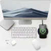 A desk setup with a computer monitor, keyboard, mouse, wireless earbuds, and a smartphone charging on a wireless charger. Produktbild-Vorschau