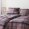 A close-up view of a plaid patterned duvet cover and pillowcase set on a bed.