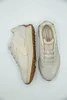 A pair of cream-colored Skechers sneakers are displayed on a white background. Produktbild-Vorschau