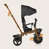 A side view of a brown and black Lionelo Kori tricycle against a plain beige background. Anteprima dell’immagine prodotto